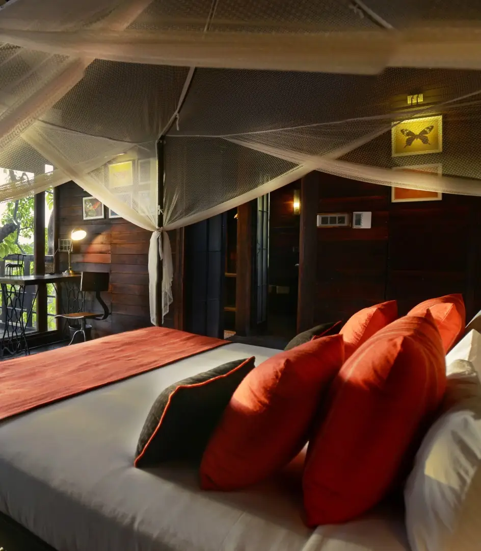 Tree house interior with four-poster bed at Pench Tree Lodge